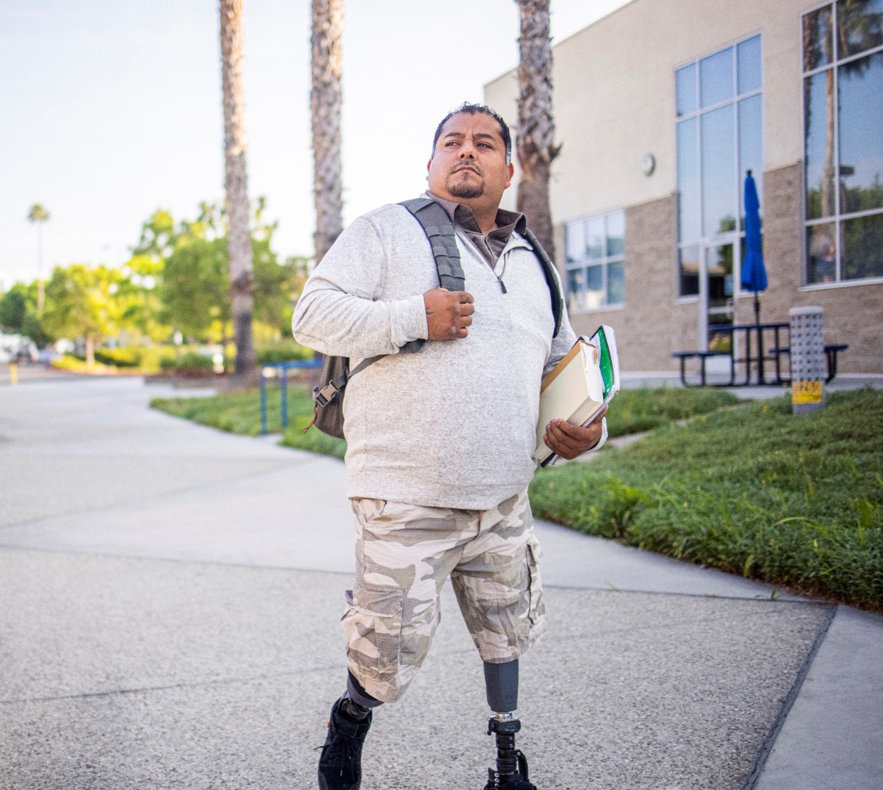 A young Hispanic American Veteran college student going to class. He is a double amputee.