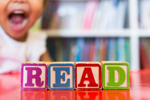 Closeup of kids alphabet wooden blocks arranged to spell "read"