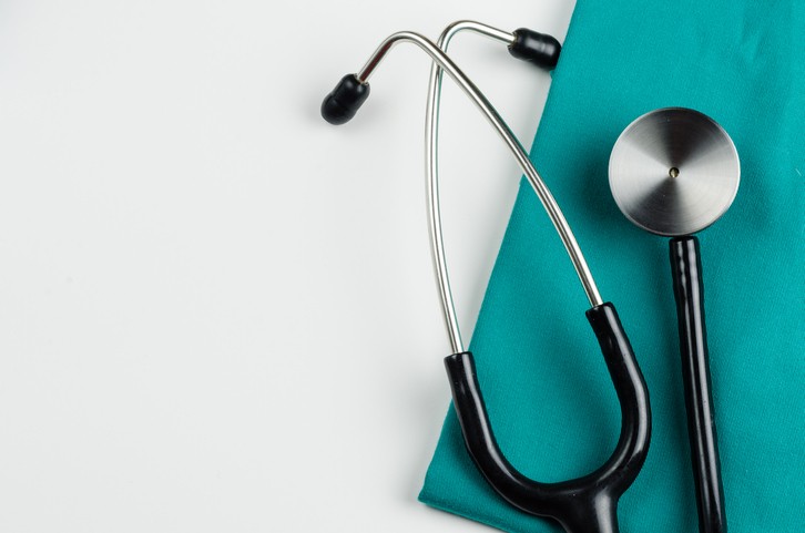 stethoscope and scrubs on white background