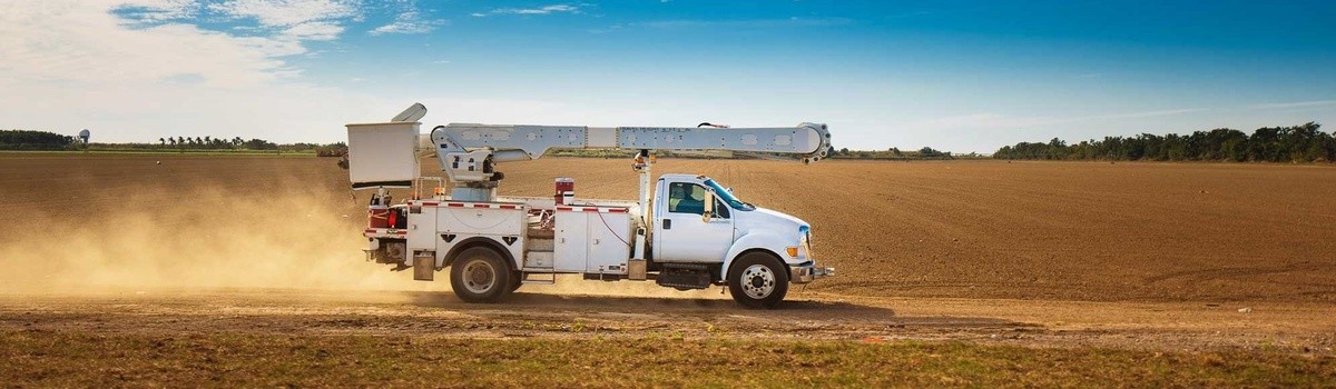 Utility truck driving on dirt road